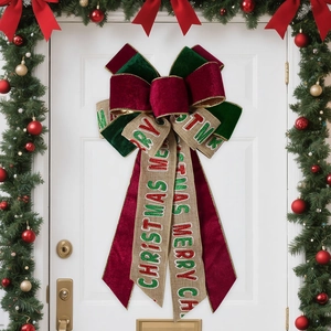 Large Christmas velvet and burlap bow with Merry Christmas text on pine needle wreath
