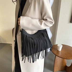 Fashionable black tassel shoulder bucket bag with golden hardware in a modern setting