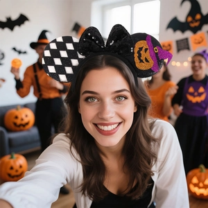 Close-up of Halloween Mickey ears headband with sequin pumpkin and black bow on model