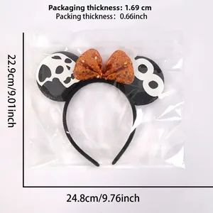 Detail view of Halloween Mickey ears with orange sequin bow and skull motifs