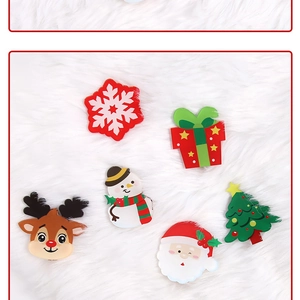 Close-up of Christmas acrylic clips with Santa, reindeer and snowman on faux fur