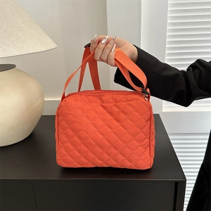 Quilted bright orange nylon shoulder bag with adjustable strap and diamond lattice pattern