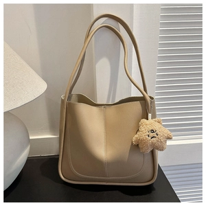 Close-up of light khaki PU leather tote bag with star plush charm and vertical stitching