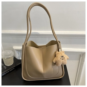 Detail of beige PU leather tote bag featuring a cute plush star charm on the handle