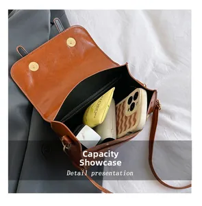 Dettaglio della capacità interna della borsa a tracolla marrone vintage con oggetti