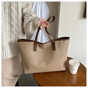 Détail de la texture tressée et de la poignée marron de ce sac cabas couleur kaki