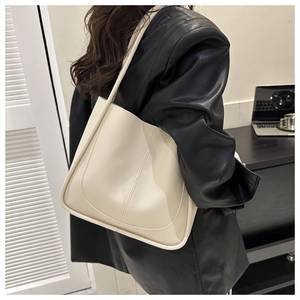 Détail d'un sac cabas minimaliste en cuir PU blanc crème porté par un mannequin pour le travail