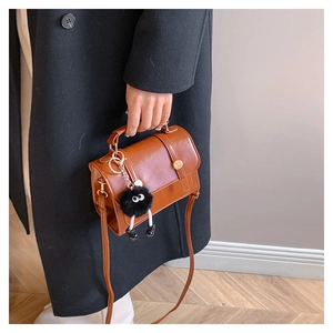Piccola borsa vintage marrone in ecopelle con un ciondolo a mostriciattolo in pelliccia