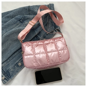 Détail du sac bandoulière en nylon matelassé rose clair avec bandoulière et smartphone