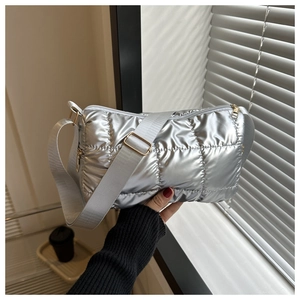 Gros plan d'un sac à bandoulière matelassé argenté avec finition métallique brillante