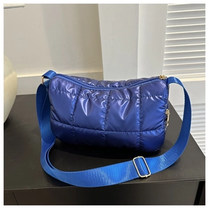 Gros plan sur le tissu en nylon matelassé bleu brillant et le zip doré de qualité