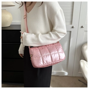 Détail du sac bandoulière matelassé rose avec fini satiné et bandoulière réglable