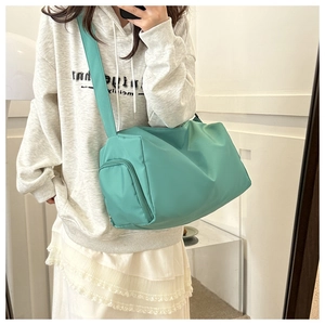 Mint green nylon crossbody gym bag with side zipper pocket shown on a model