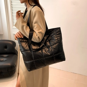 Quilted tote bag in black puffer fabric shown on model for high capacity styling