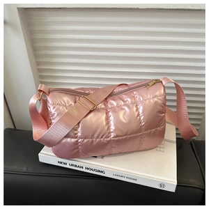 Detail of pink metallic quilted crossbody bag with golden zipper and wide shoulder strap