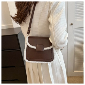 Brown leather crossbody bag with white faux fur trim shown on a model