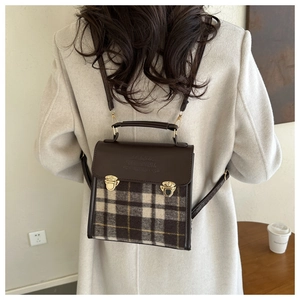 Detail of British retro plaid wool and brown PU leather backpack with gold buckles