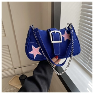 Detail of dark blue canvas saddle bag featuring pink star patches and a silver metal buckle