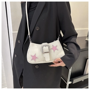 Detail of white canvas saddle bag with pink star patches and metallic buckle on model