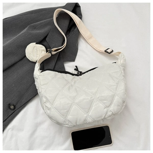 Detailed macro view of white quilted nylon crescent bag with adjustable textile strap
