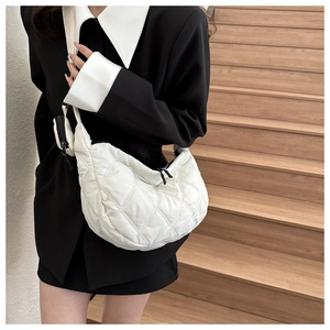 Quilted white crescent bag detail featuring matching charm and oxford fabric texture