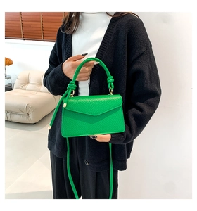 Dettaglio della borsa a tracolla verde brillante effetto serpente con chiusura dorata