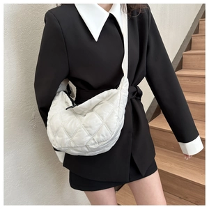 Detailed view of white quilted crescent bag with adjustable wide strap for daily casual wear
