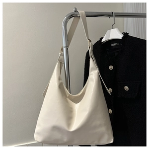 Detail of a large cream-white hobo tote bag in matte leather with adjustable shoulder strap