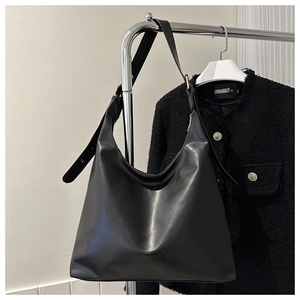 Detail of black leather hobo bag with adjustable gold buckle and large capacity capacity