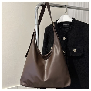 Detail of dark brown matte faux leather hobo bag with natural drape on a hanger
