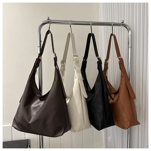 Detail view of large matte leather tote bags in dark brown, beige, black, and caramel colors