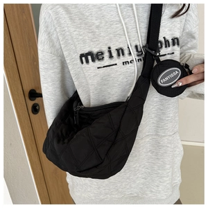 Detail of black quilted crescent crossbody bag with matching round coin purse charm