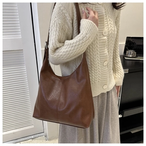 Detail of dark brown hobo shoulder bag with vertical stitching and vintage leather texture