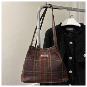 Detail of wool tote bag with vintage check pattern and leather brand label on front