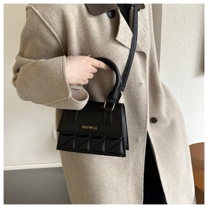 Detail of black crossbody square bag with geometric quilting and gold metallic logo