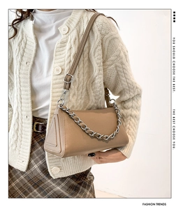 Detail of a brown textured faux leather handbag with a chunky silver chain and strap