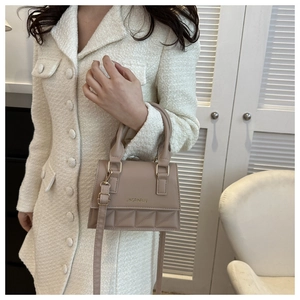 Detail of beige quilted crossbody bag with gold hardware and leather finish