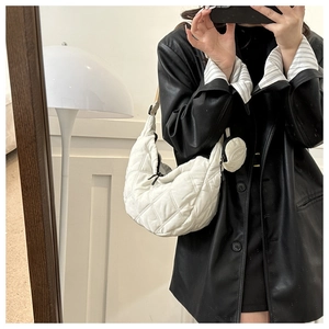 Close-up of white quilted crescent bag with round coin purse and nylon rhombic pattern
