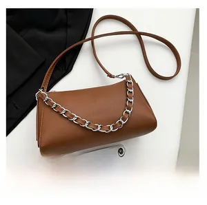 Brown litchi grain leather crossbody bag with silver metal chain and smartphone for size scale