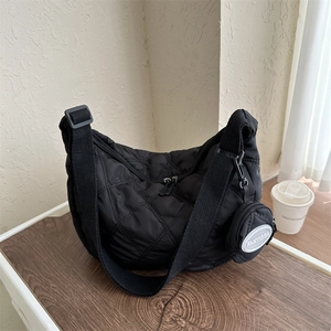 Black quilted crossbody bag with rhombic pattern and a small detachable round pouch