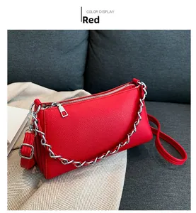 Detail of red small square bag showing litchi texture and silver chunky chain handle