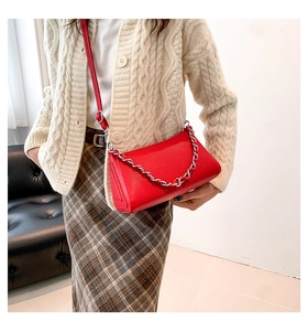Red leather underarm bag featuring a bold silver chain and slim shoulder strap