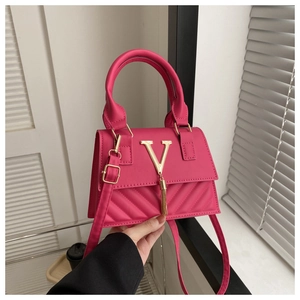 Détail du sac à main rose avec fermoir en V doré et pampille à franges élégante