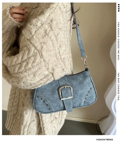 Detalle del bolso baguette azul retro con hebilla plateada y remaches finos