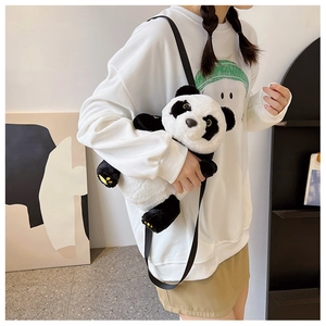 Detail of soft plush panda crossbody bag with yellow paw embroidery and fine strap