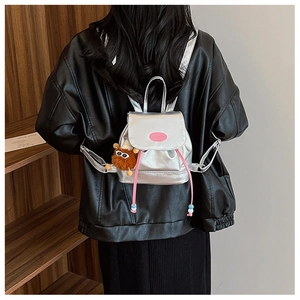 Mini silver metallic backpack with pink details and a plush charm shown on person