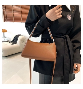 Detail of vintage brown lychee grain leather crossbody bag with chain and leather strap