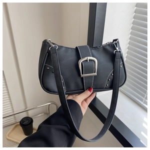 Detalle de bolso de hombro Y2K negro con costuras blancas y hebilla metálica plateada grande