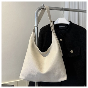Detail of off-white lychee grain leather hobo bag with adjustable metal buckle strap