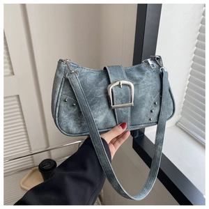 Detalle del bolso bajo el brazo de mezclilla azul vintage con hebilla plateada y remaches